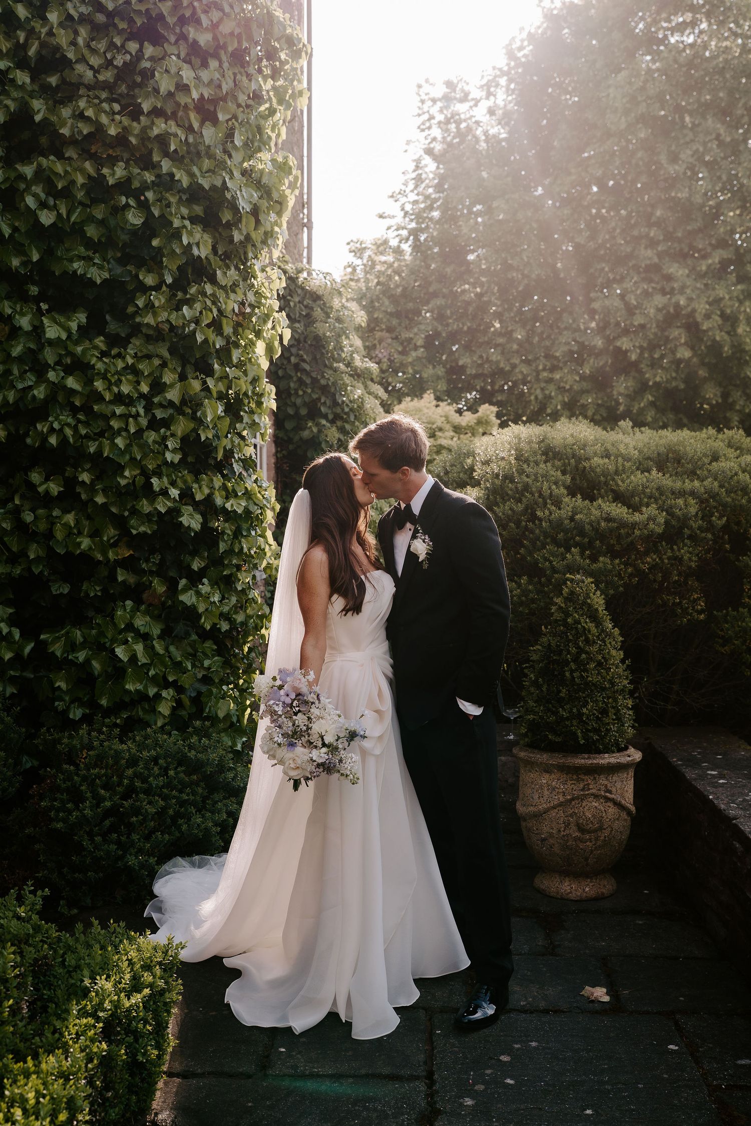 bride and groom kissing in the setting sun at dewsall court in herefordshire