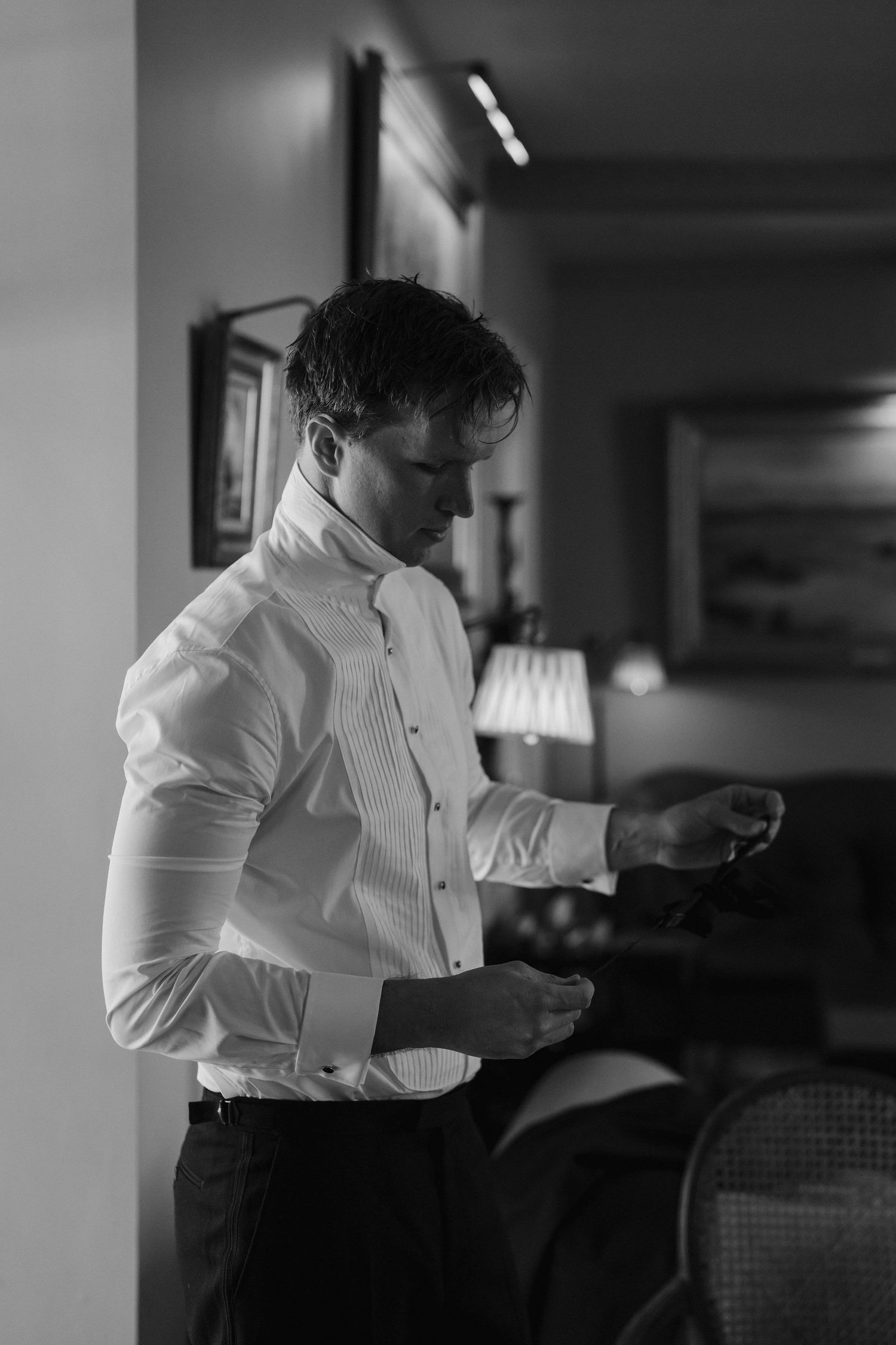 groom getting ready, adjusting his bow tie at dewsall court in herefordshire