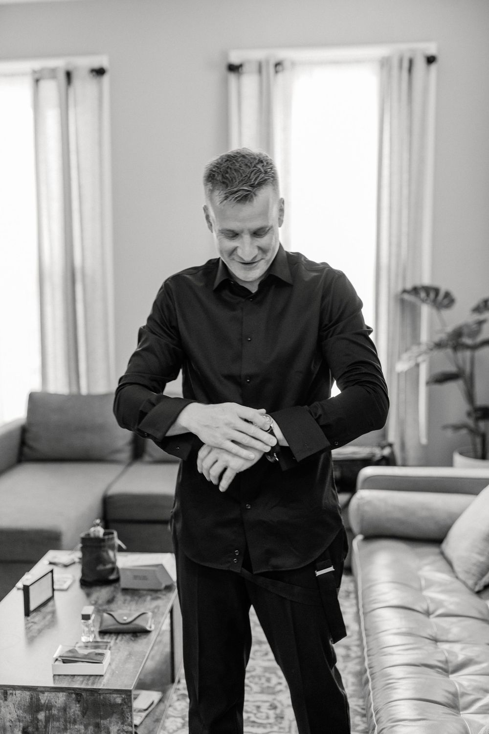 A series of black and white photos showing someone sitting in a living room looking at a book.