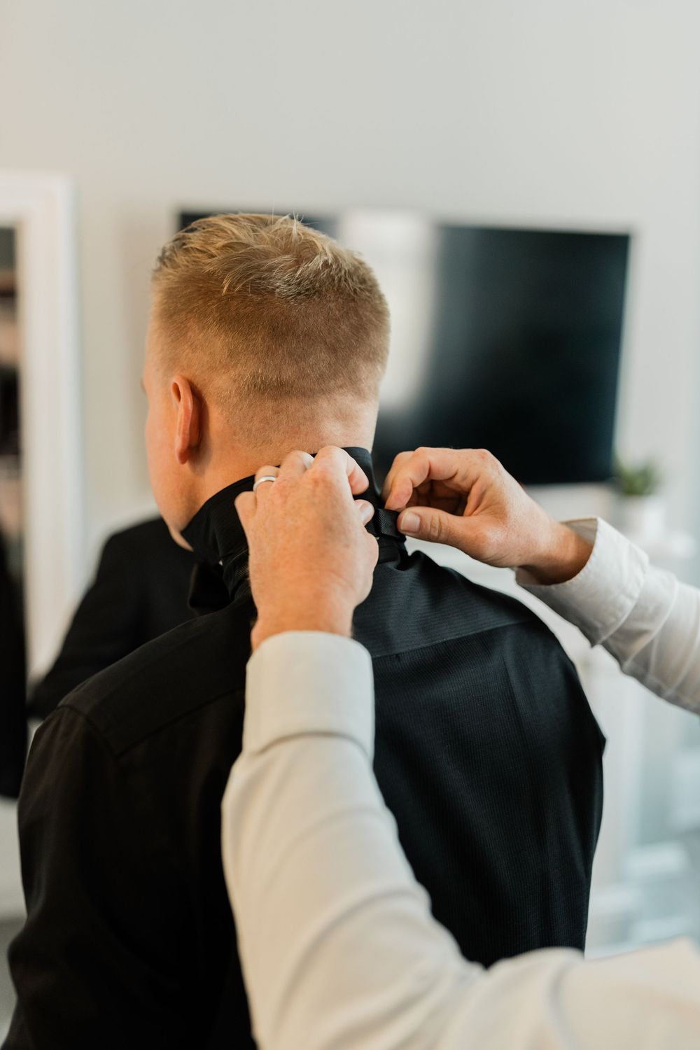 Close-up sequence showing the adjustment of a black suit collar and tie.