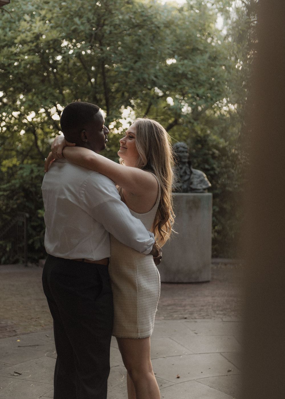 A couple shares a dance and embrace on an outdoor terrace.