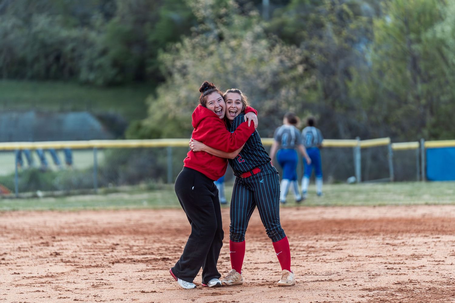 Players on a softball field demonstrate proper fielding techniques during a practice session.