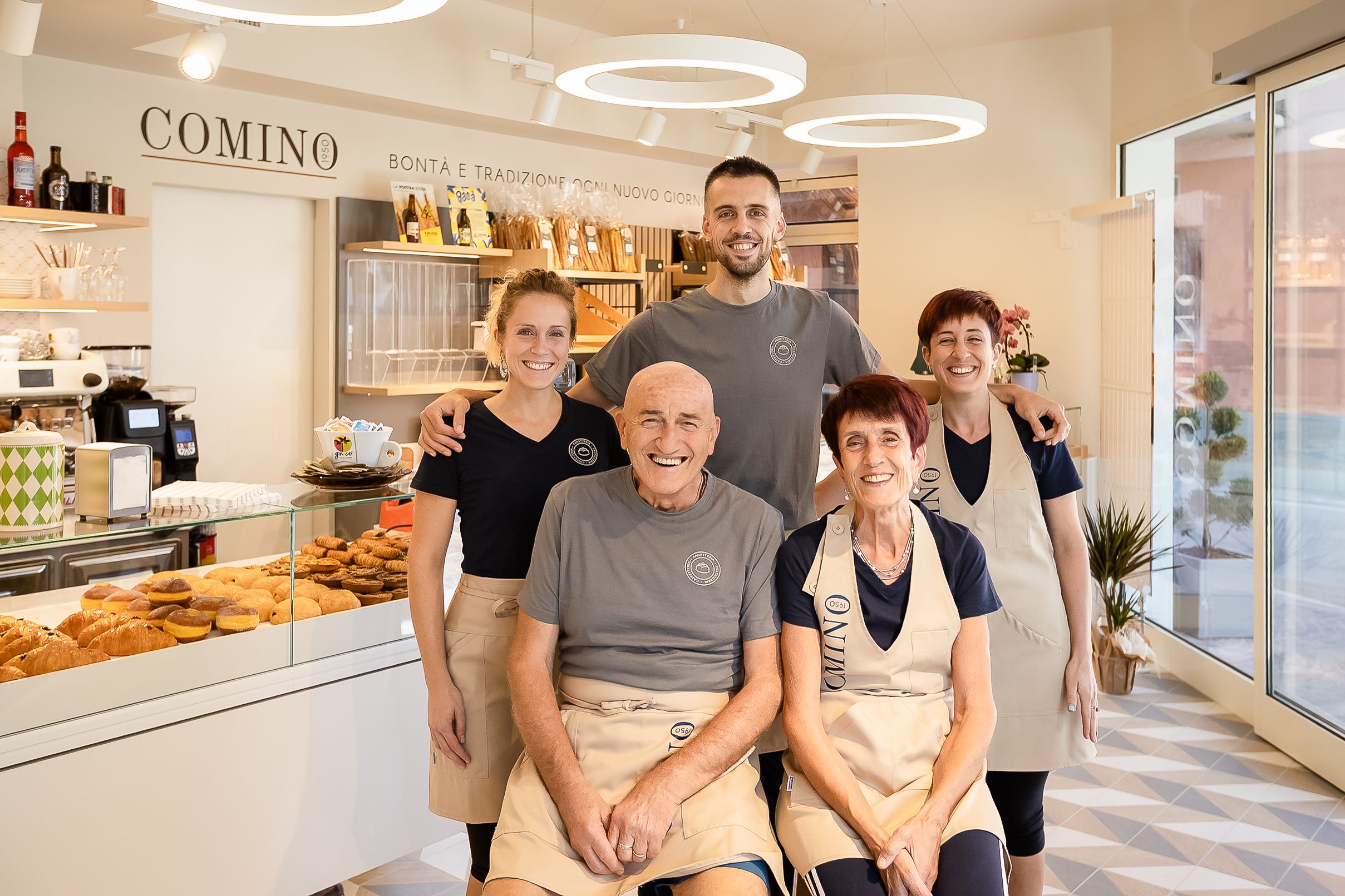Modern bakery interior with curved ceiling lights and glass display cases showing fresh pastries.