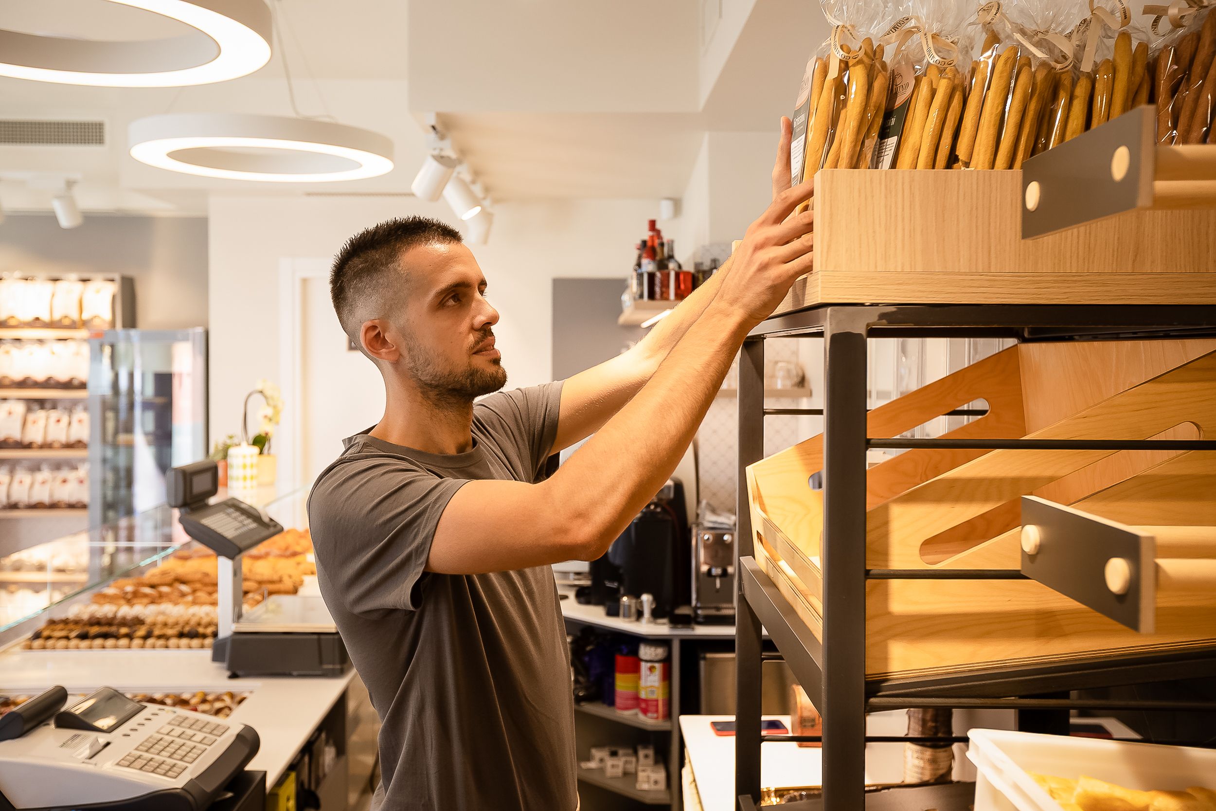 A series of images showing a barista making coffee and operating an espresso machine in a modern cafe setting.