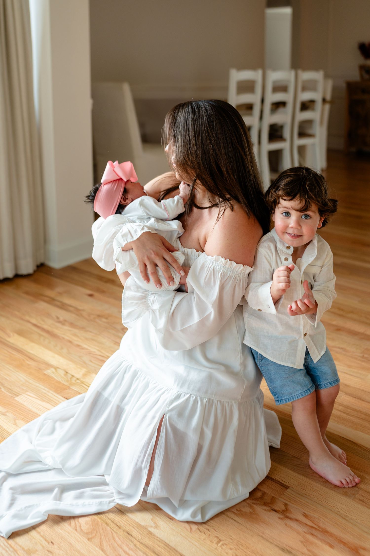 A sequence of images showing two children in white dresses playing and twirling on a hardwood floor.