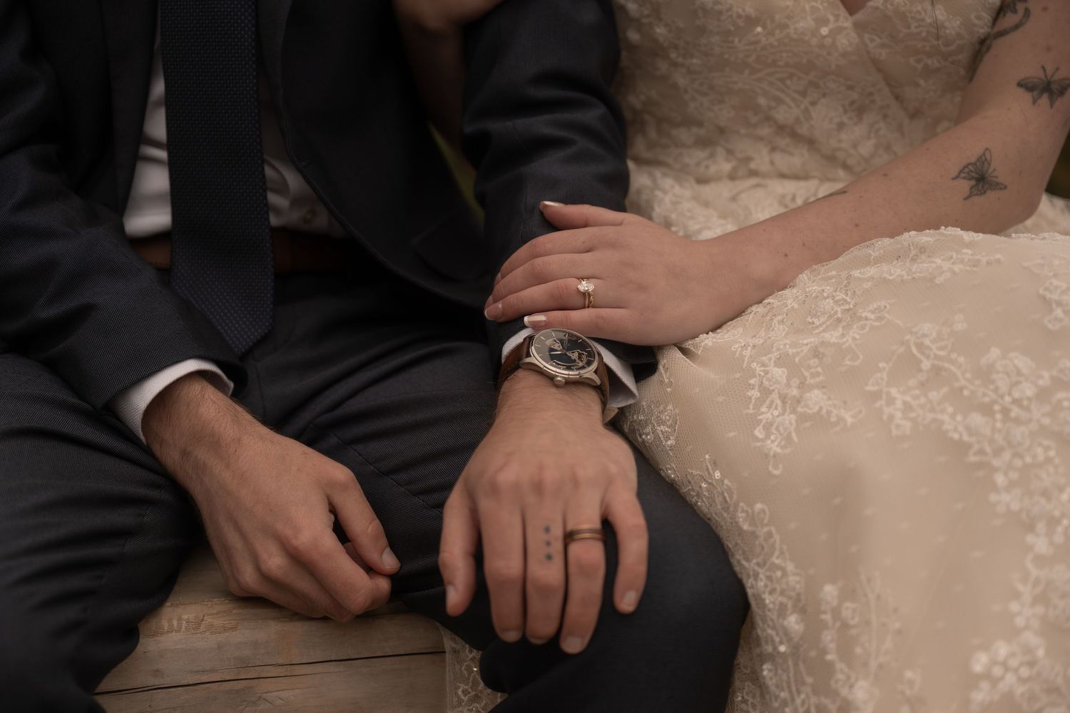 A couple sits side by side showing their wedding rings while eloping in Mt. Rainier National Park.
