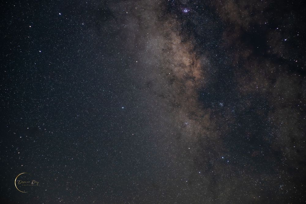 A stunning long exposure photograph shows the Milky Way galaxy stretching across the dark night sky in texas
