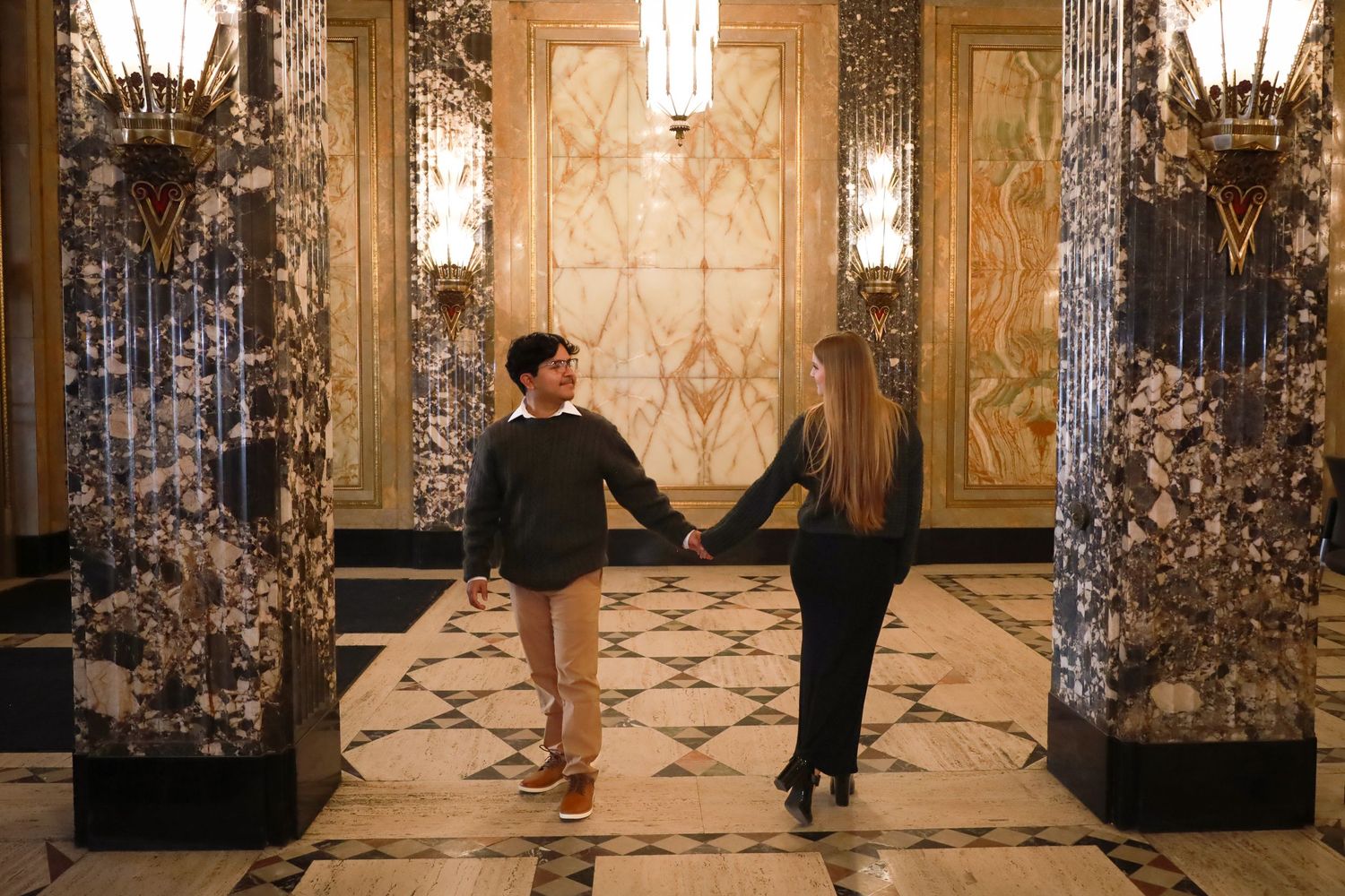 Elegant hallway with ornate marble columns and decorative lighting creating a luxurious atmosphere.