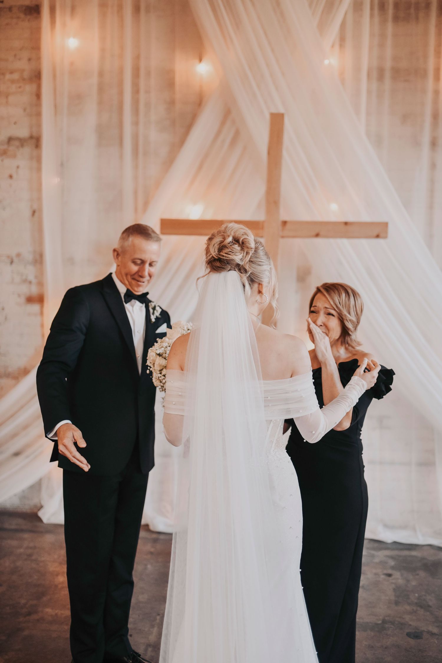 Bride revealing her dress to mom during first look moment