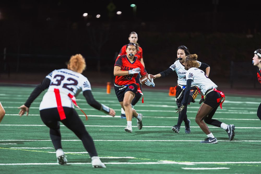 Girls flag football player running through players with the ball