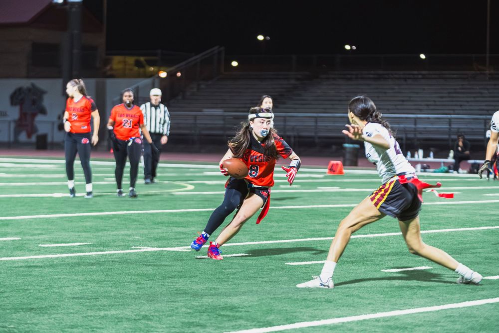 Girls flag football player cutting right with the ball