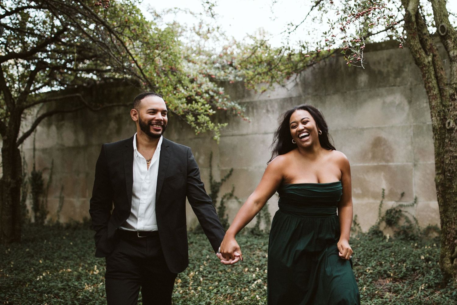 A couple shares an intimate moment together in a lush garden setting during a romantic photoshoot.