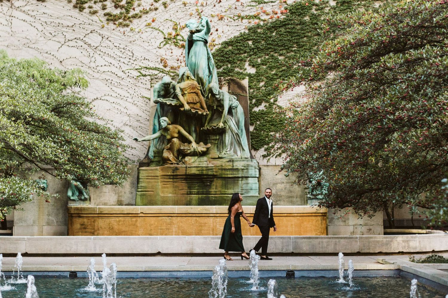 A couple stands in front of a stone wall during a wedding ceremony at a historic venue.