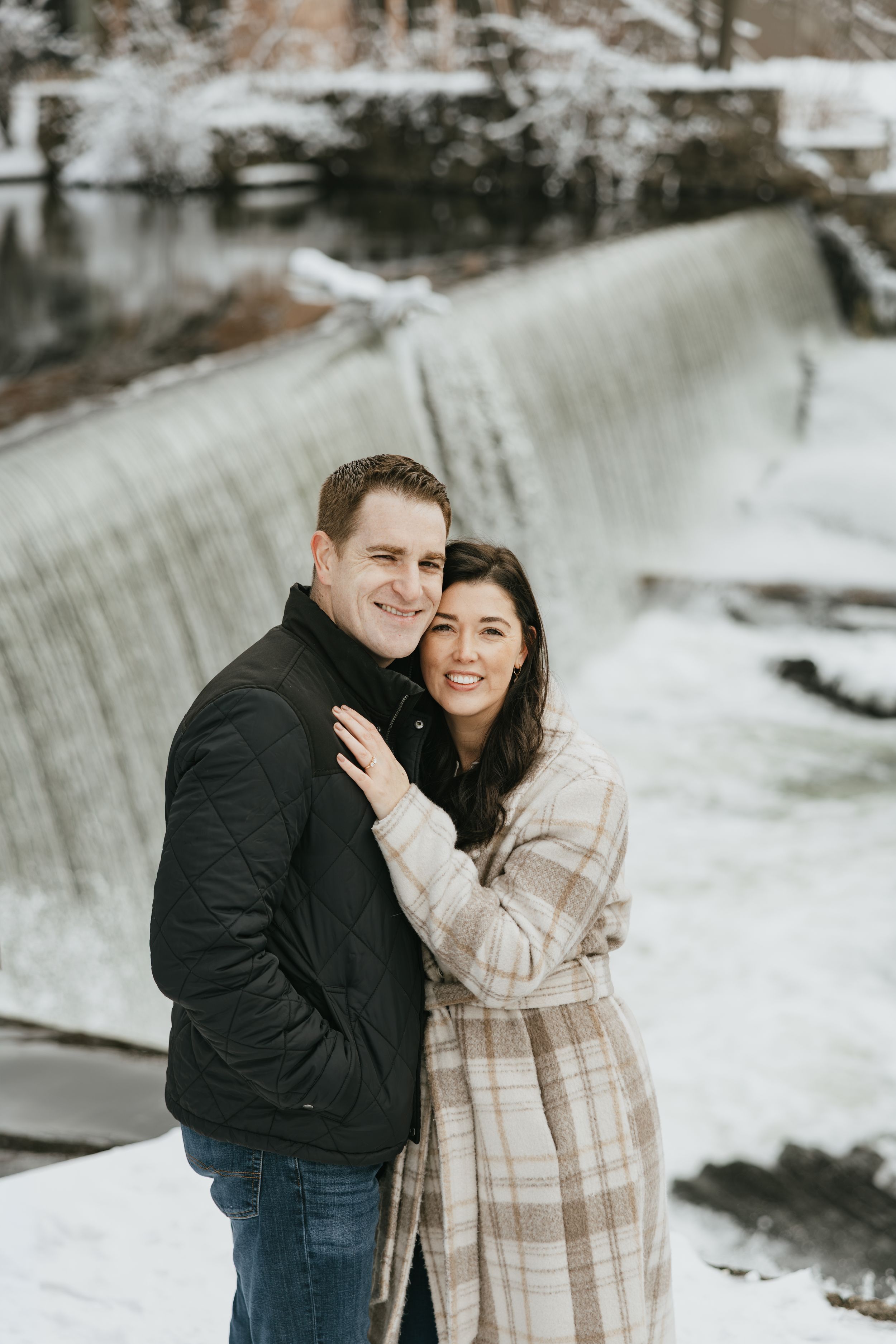 A couple shares tender moments together in a snowy winter landscape during an outdoor photoshoot.