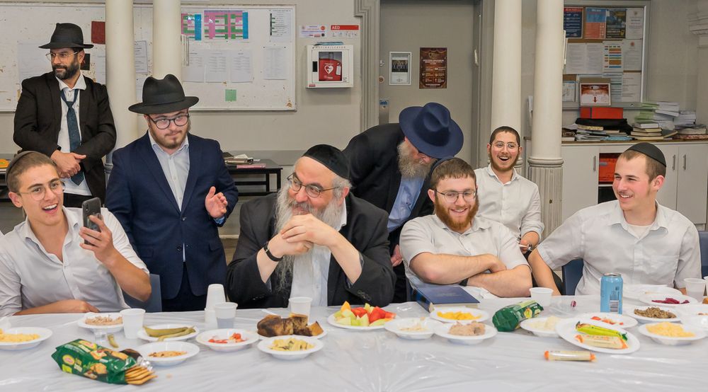 A panoramic view of people sitting at tables in a meeting or training room during a meal or gathering.