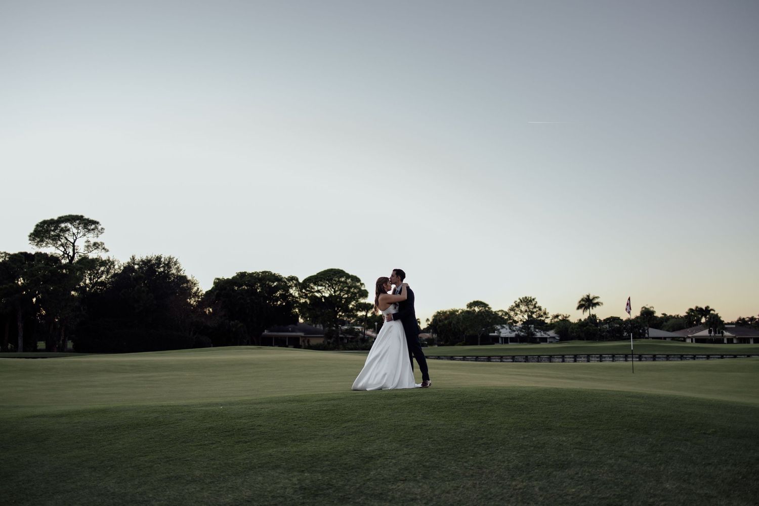 An elegant winter wedding reception features romantic white floral decor and candlelight in a grand venue setting.