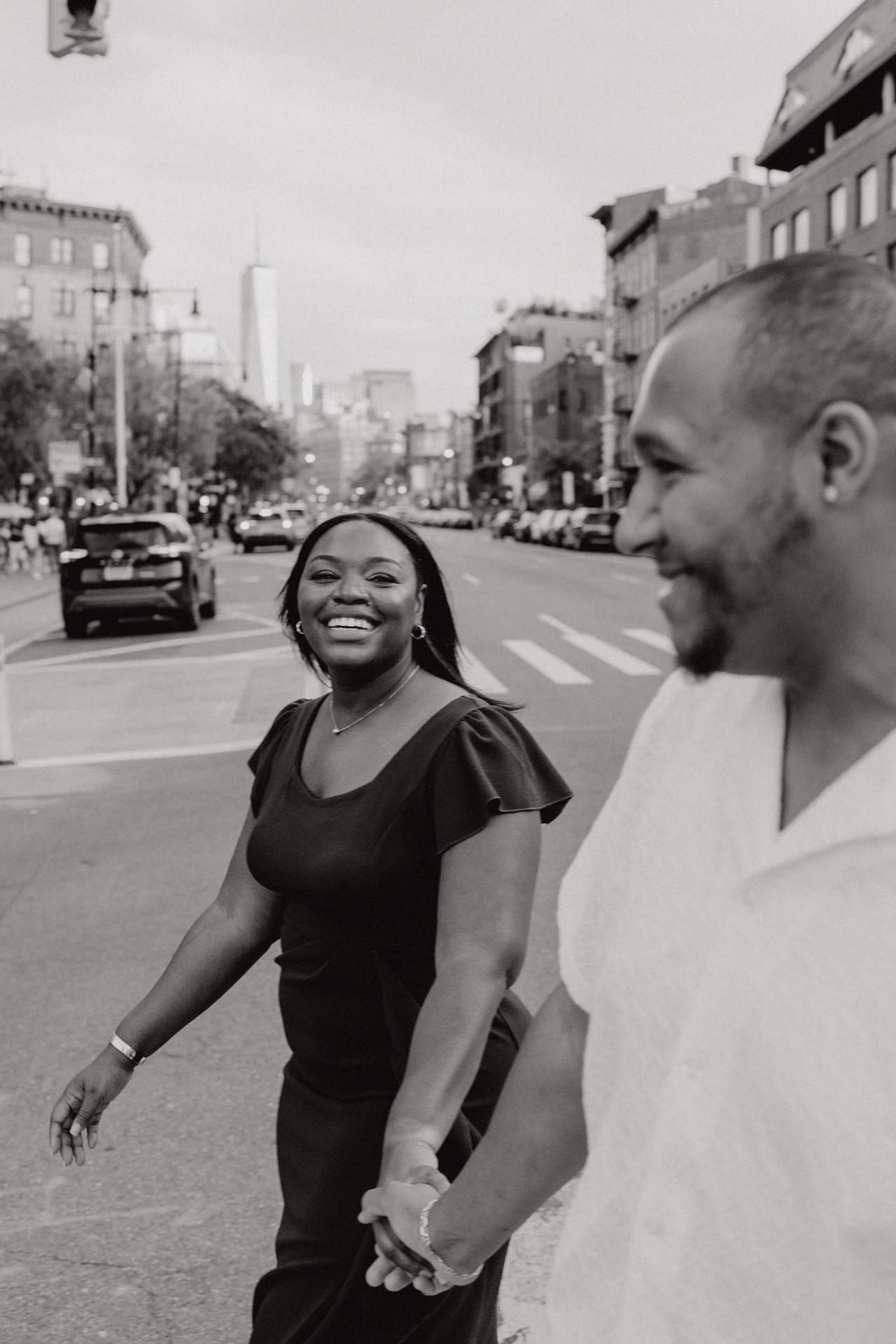 A series of black and white photographs showing two people sharing joyful laughter together on a city street.