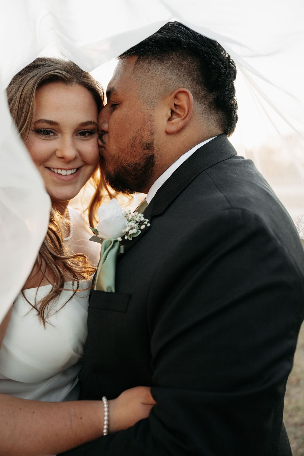 Intimate wedding portrait of a couple sharing tender moments together during sunset.