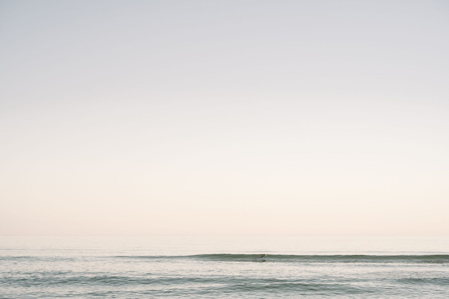 A sweet beach scene with mother and baby sharing a joyful moment on the sand.