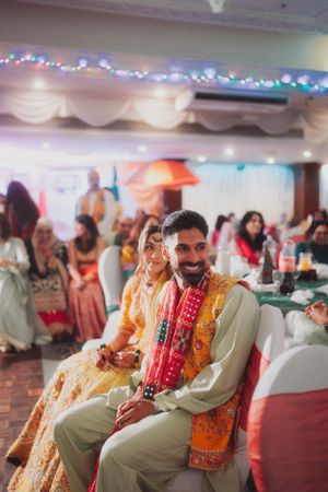 Wedding celebration with guests seated in traditional Indian formal wear under decorative lights.