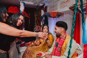 Joyful celebration moment at Indian wedding with guests in traditional attire.