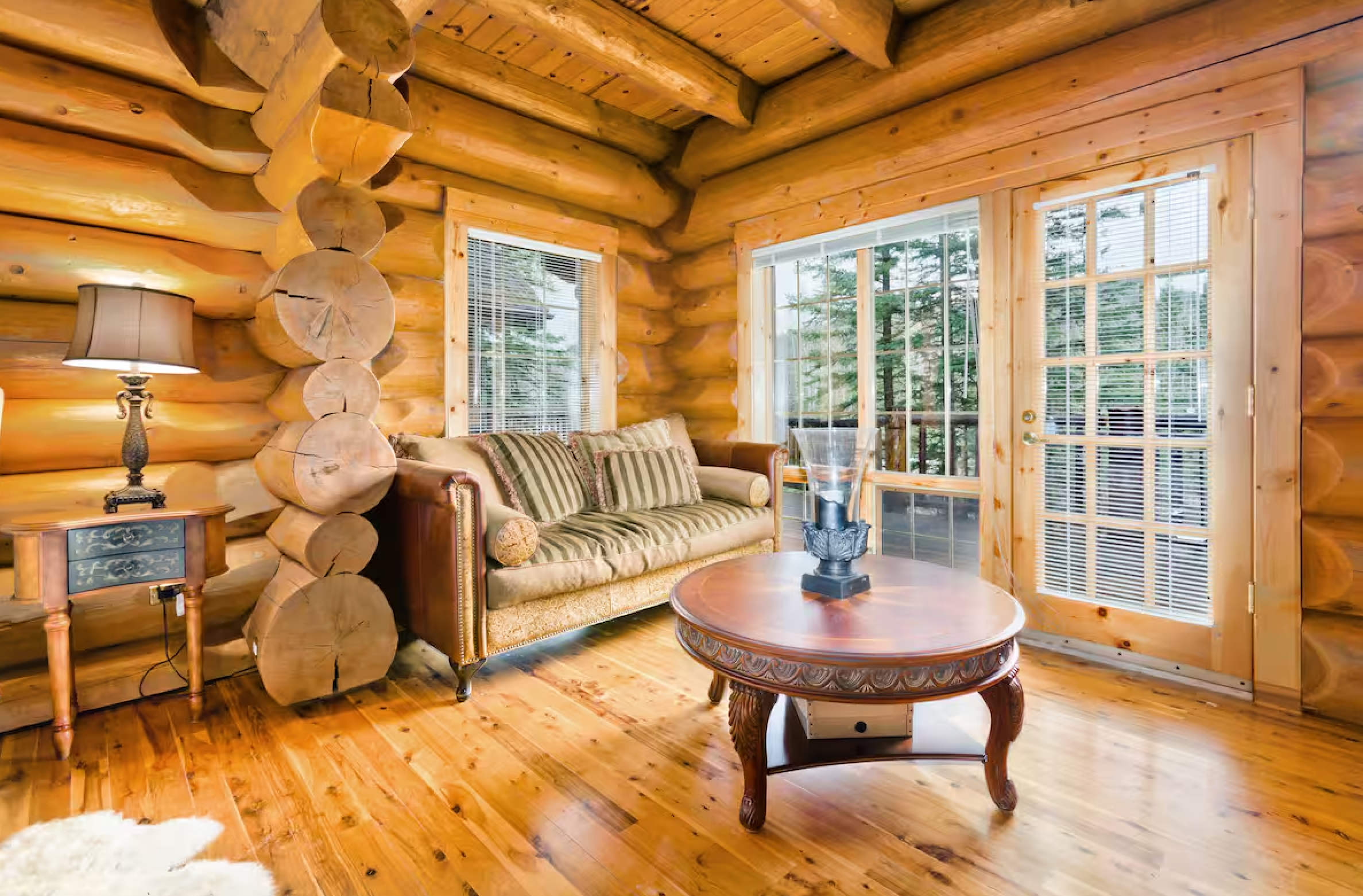 Bright log cabin living room with hardwood floors and French doors.