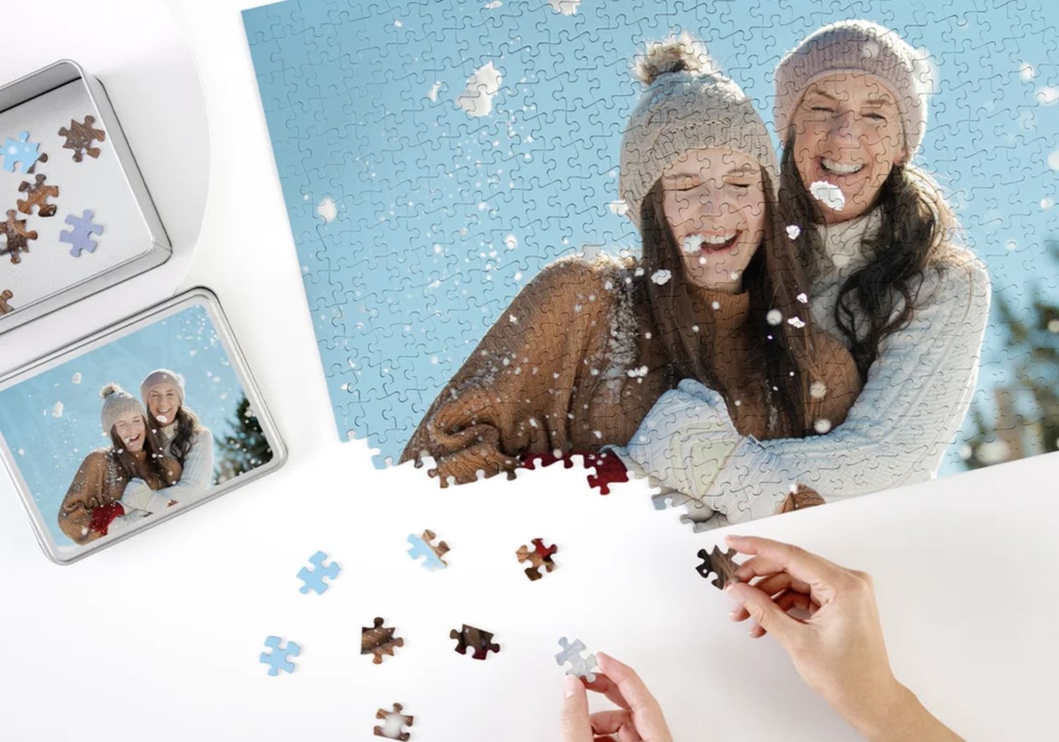 Two people assembling a personalised jigsaw puzzle of a photo made in a snowy, festive setting. Vivitu photo puzzles.