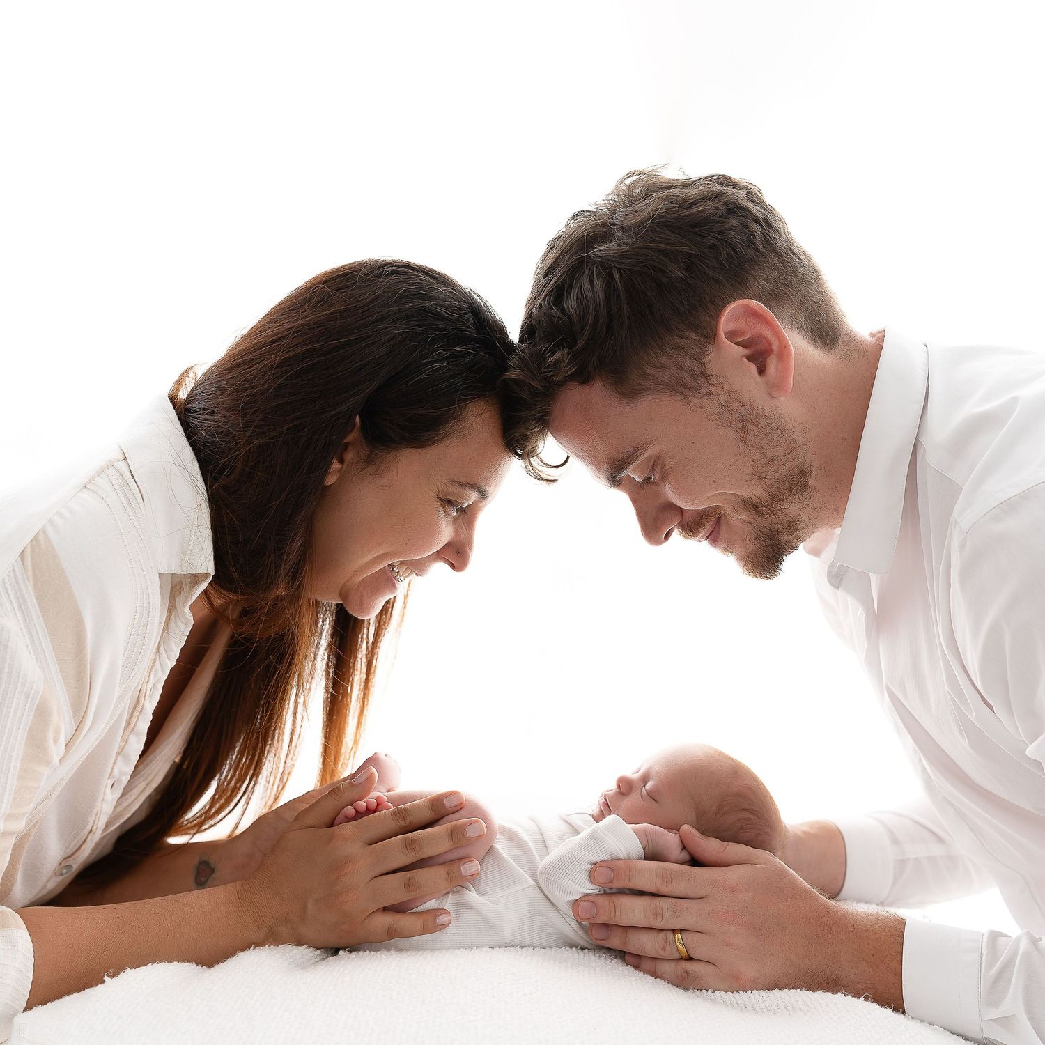Intimate black and white portrait of couple with newborn baby.