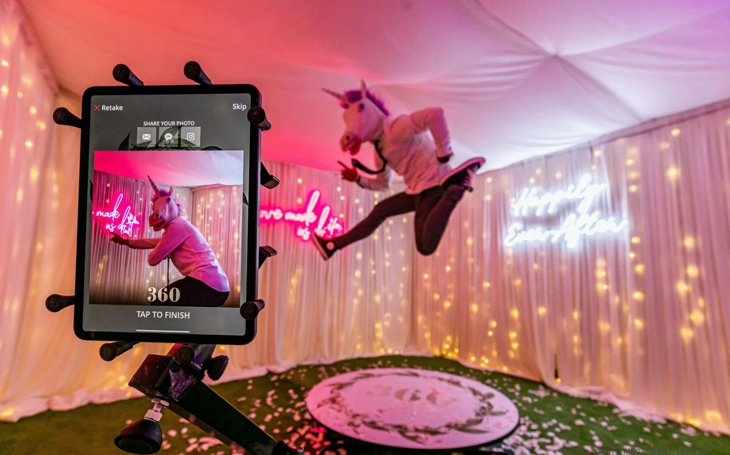 360-degree photo booth setup with a smartphone recording a guest dancing, surrounded by warm fairy lights. 360 video booth vivitu party 360