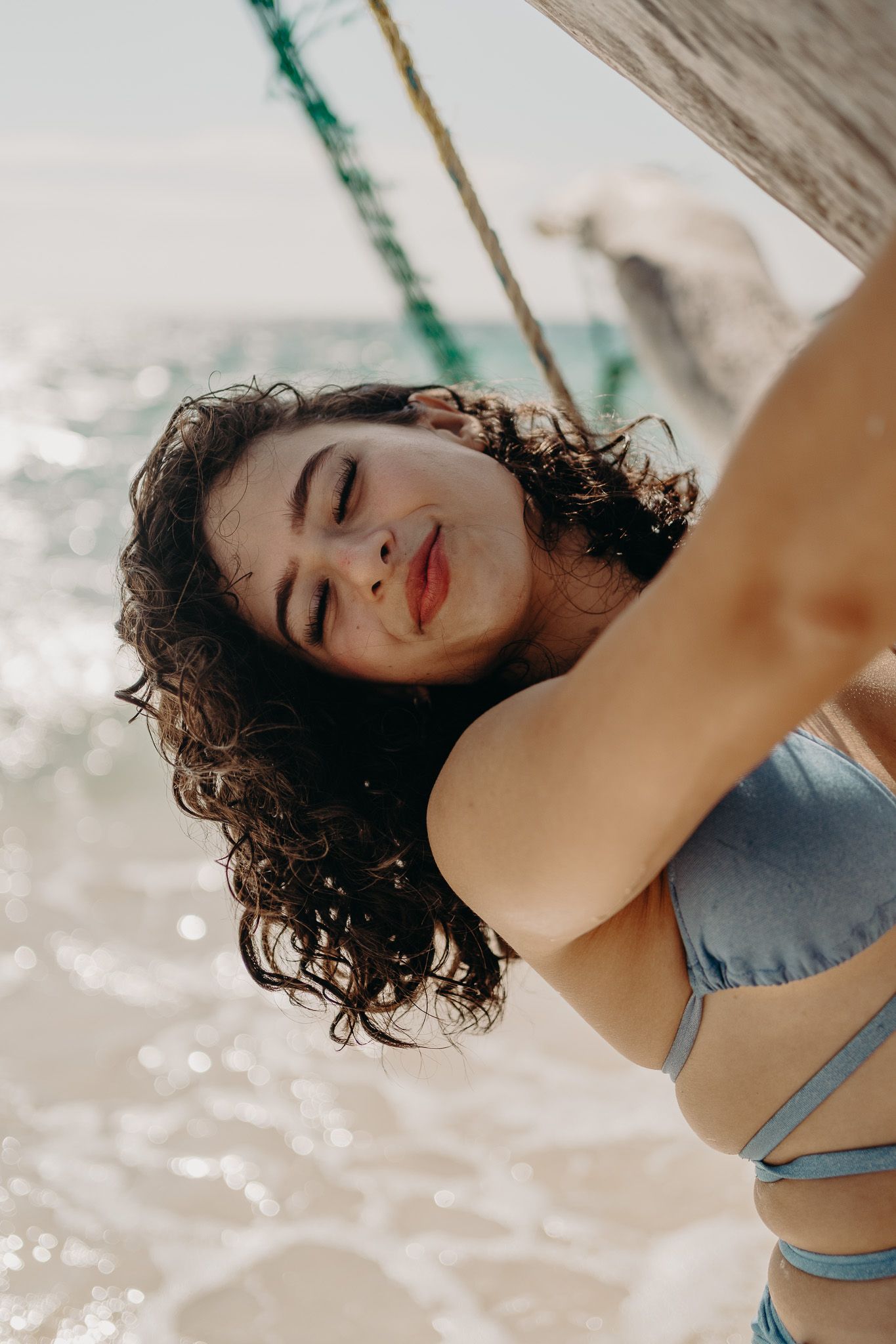 Close-up beach portrait showing curly hair and joyful expression photoshoot in Puerto Morelos.