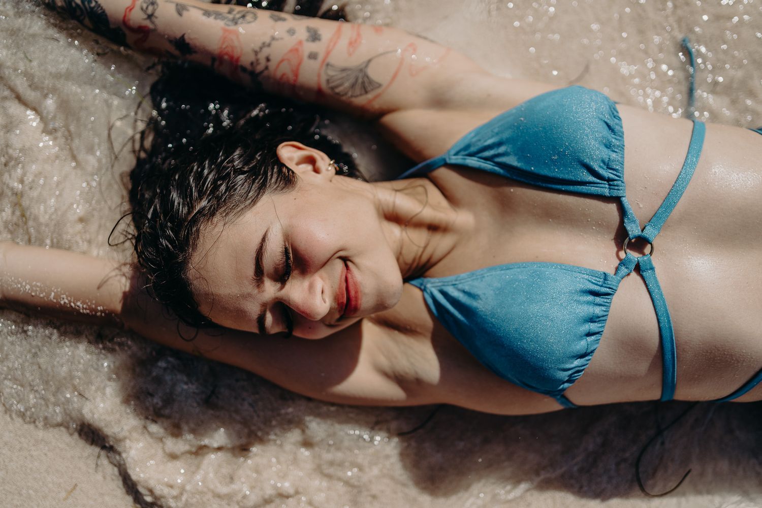 Candid beach moment in blue bikini with splashing water photoshoot in Puerto Morelos.