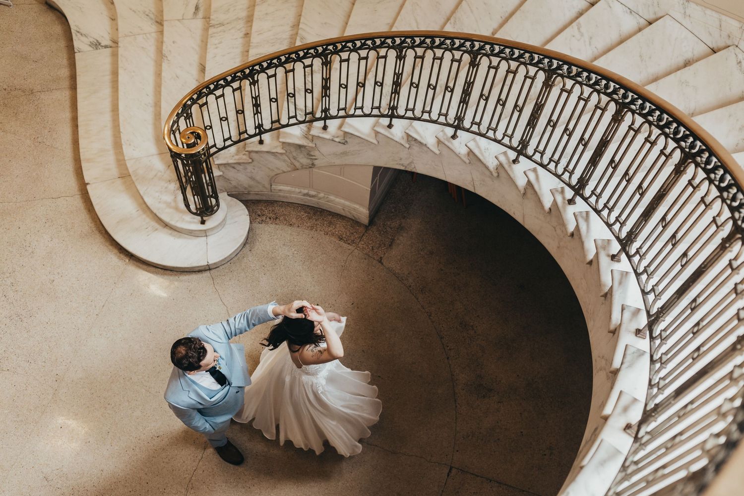 Artistic overhead view of a curved staircase with flowing white fabric creating elegant lines.