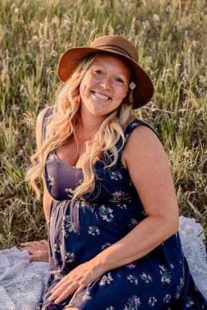 Pregnant woman cradling her belly in a wildflower field
