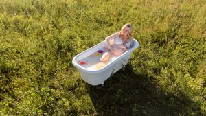 clawfoot milk bath maternity session with fresh flowers floating in tub