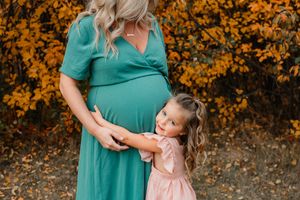 toddler hugging her moms pregnant belly for maternity session