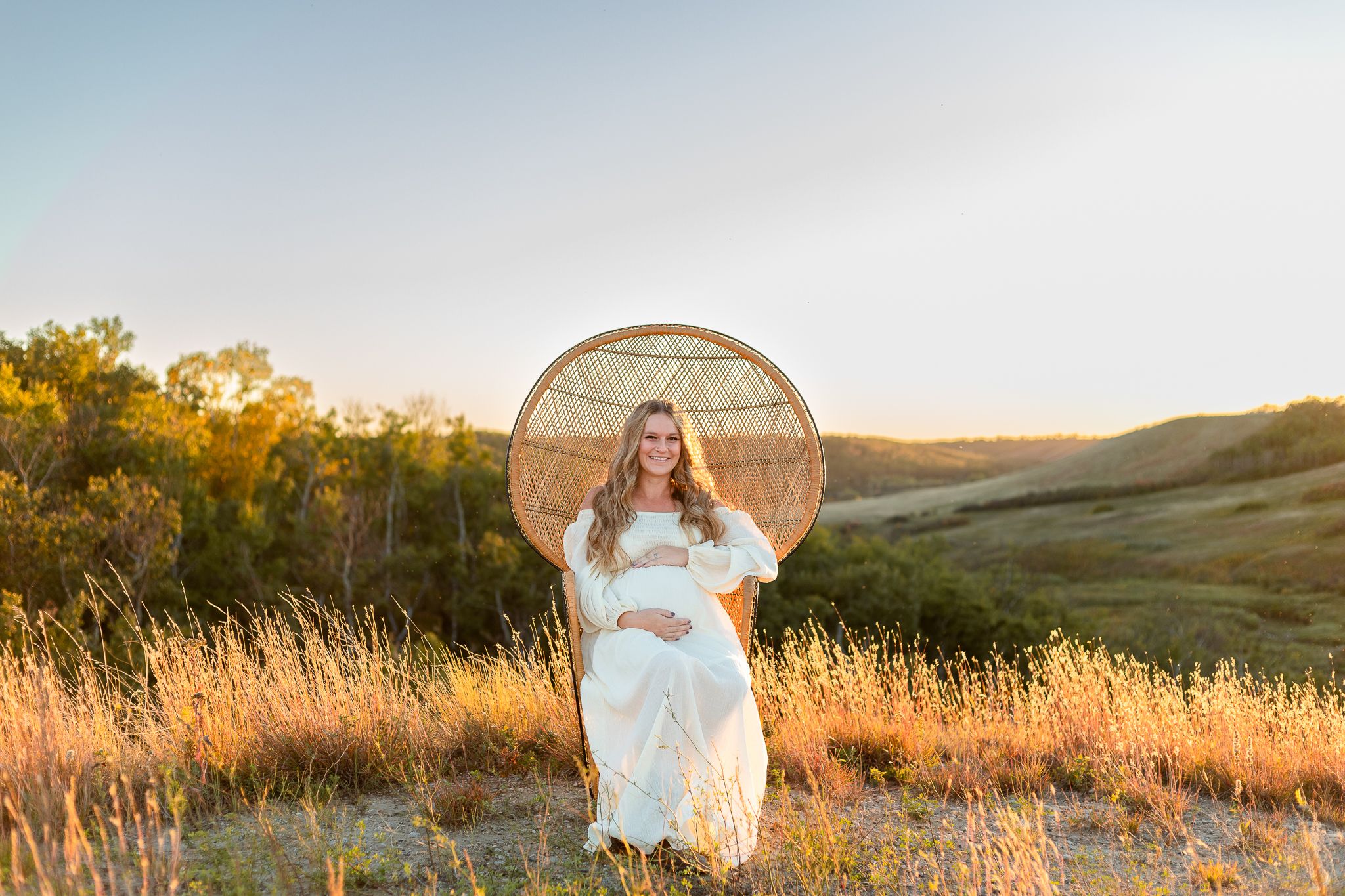 valley views at sunset with pregnant woman sitting on peacock chair