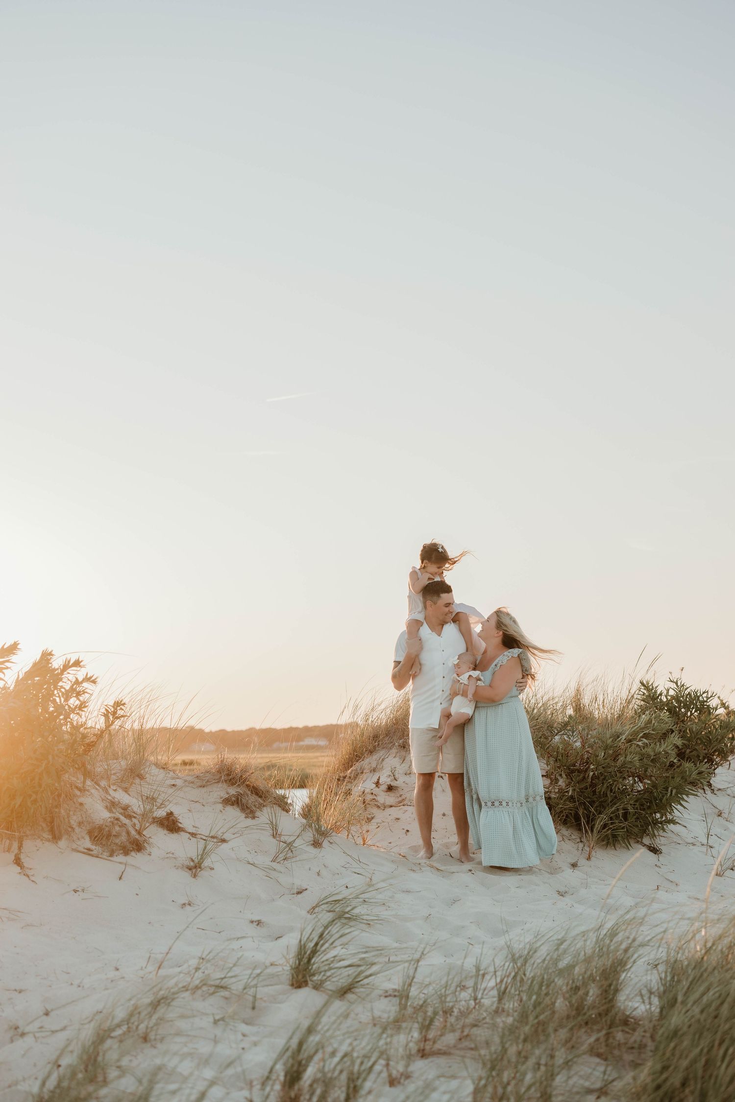 Two children sitting together on sandy beach during golden hour.