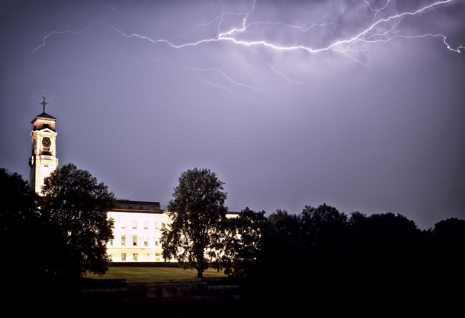 Lightning illuminates the sky behind the historic white Trent Building at the University of Nottingham