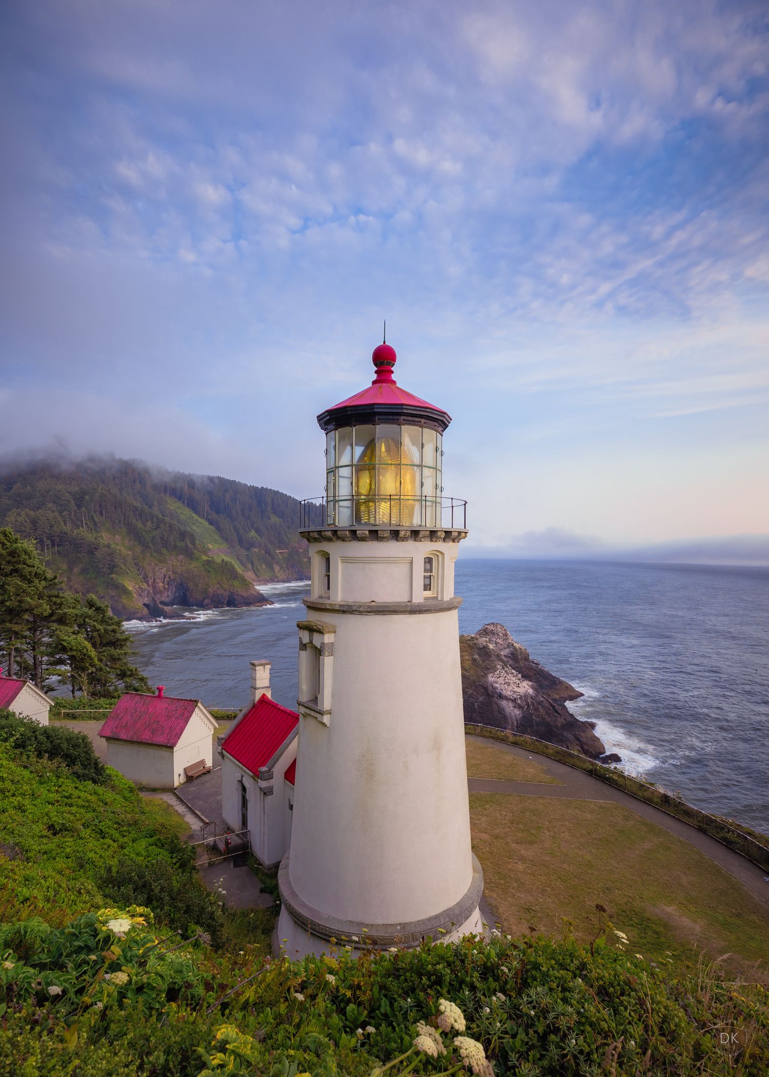 The historic Heceta Head Lighthouse stands majestically on the Oregon coast with red-roofed buildings and dramatic ocean views.