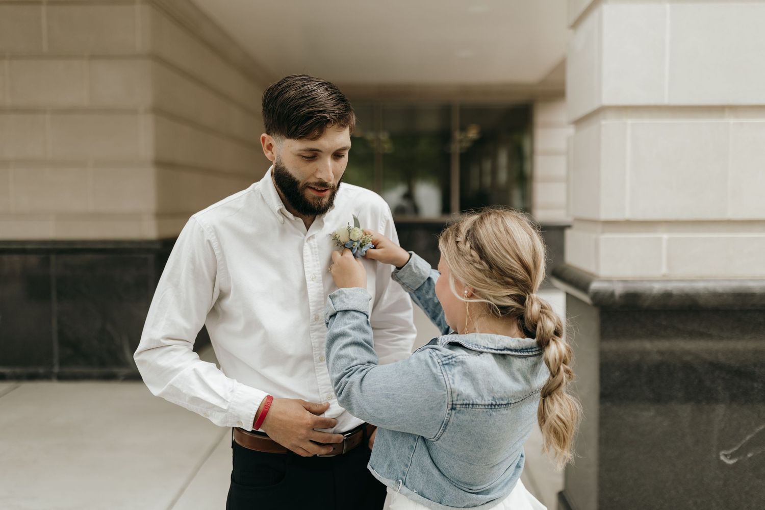 A tender moment shared outdoors near a stone building.