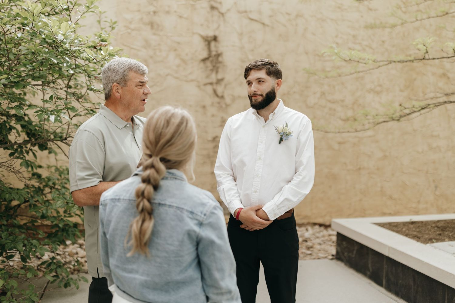 An outdoor gathering with three people during what appears to be a ceremony.