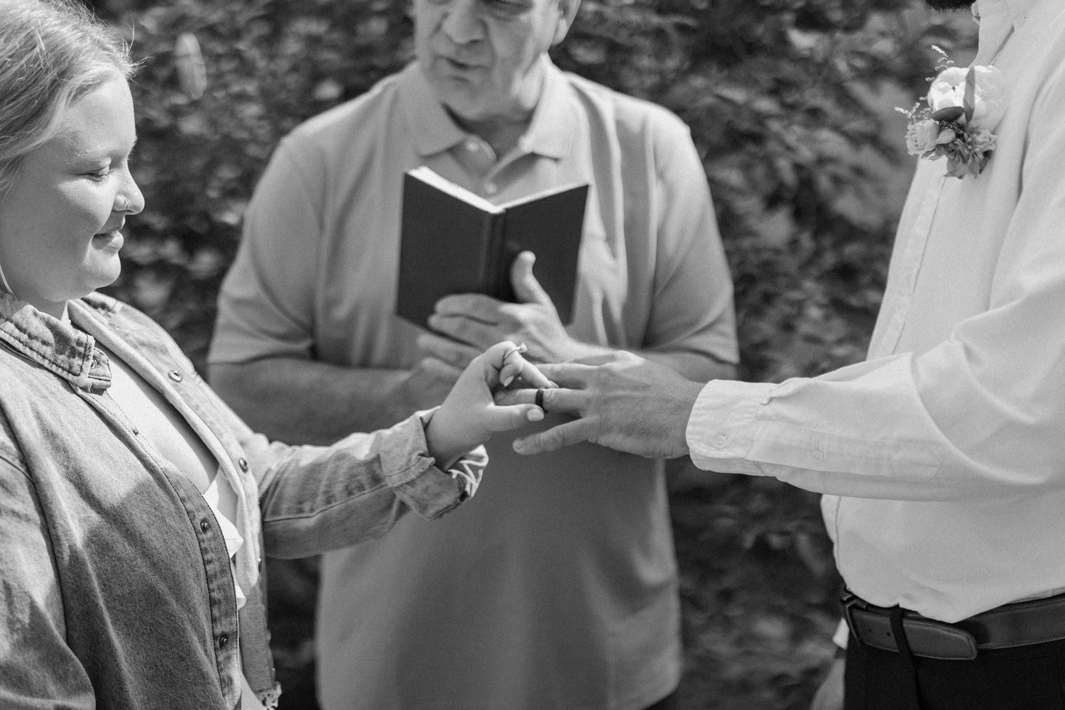 A black and white capture of a ring exchange ceremony.
