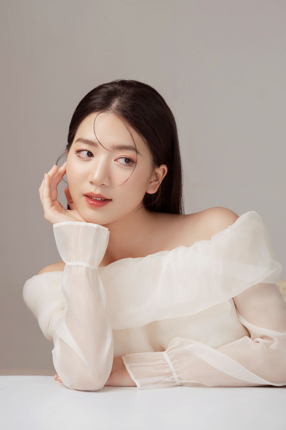 Elegant fashion portrait featuring contemporary white clothing and professional studio lighting.