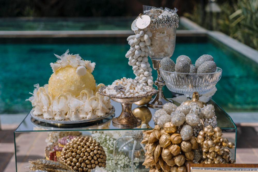 Elegant dessert and candy display with ornate stands and decorative elements arranged by a pool.