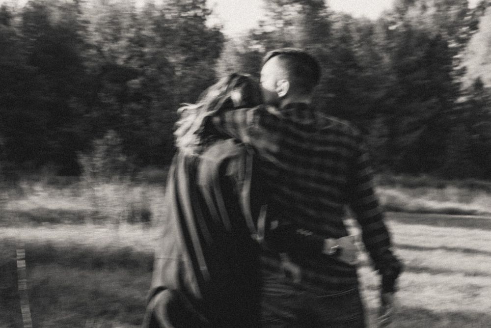 Silhouettes of people embracing in an outdoor setting at dusk.