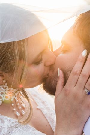 A close up image of a bride and groom sharing a passionate kiss during golden hour light. Photo taken in Chilliwack, BC.