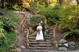 On a sunny October afternoon, a bride and groom pose for wedding portraits on the staircase at Sendall Gardens in Langley, BC.