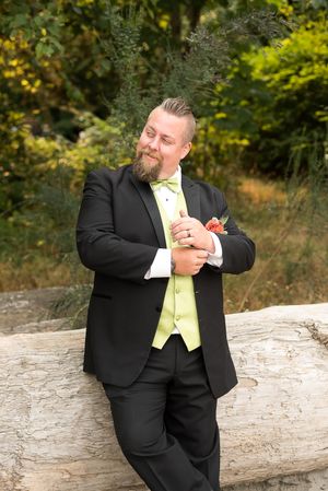 A groom stylishly posing for portraits in Vancouver, BC. Photo taken at Spanish Banks Beach by Kari Mills Photography.