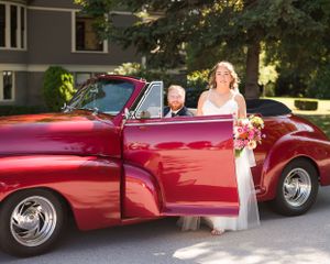 On their wedding day, a bride and groom pose with a vintage 1947 Chevrolet car, complete with a Corvette engine. Kirkland house, Ladner, BC.