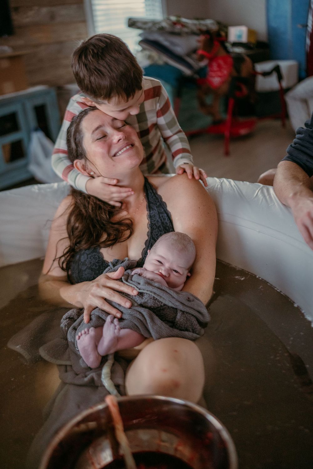 Intimate family moment during a home water birth with newborn.